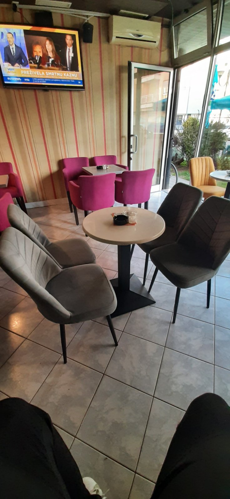 Fotelje boje ciklame i sive baršunaste stolice uz prugasti zid